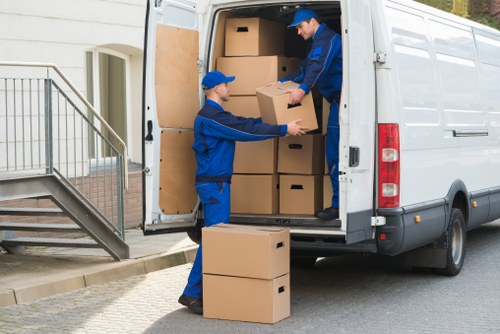 Furniture removal team handling a sofa move in a Finsbury flat building
